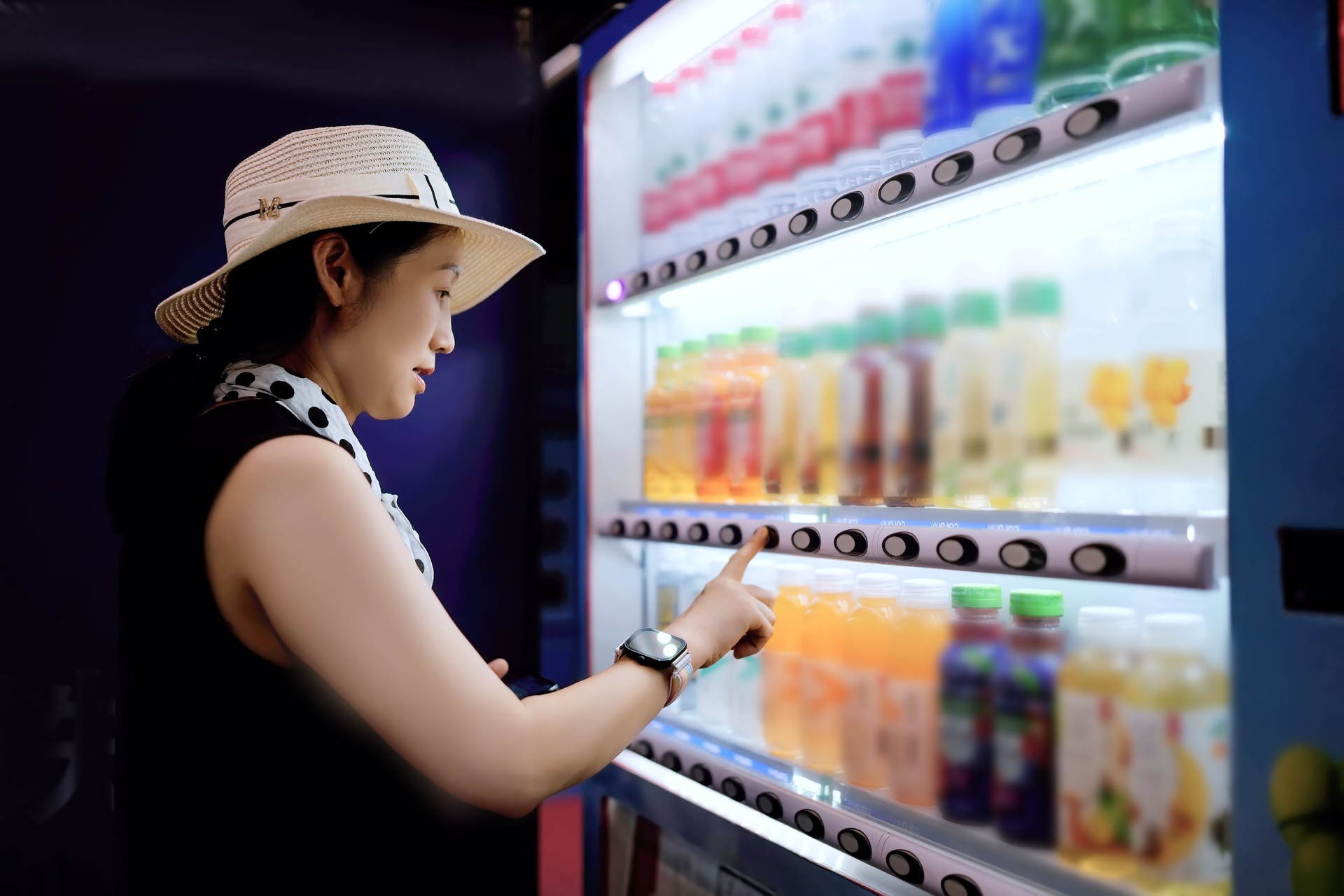 A Woman Selecting Refreshing Beverages from a Vending Machine